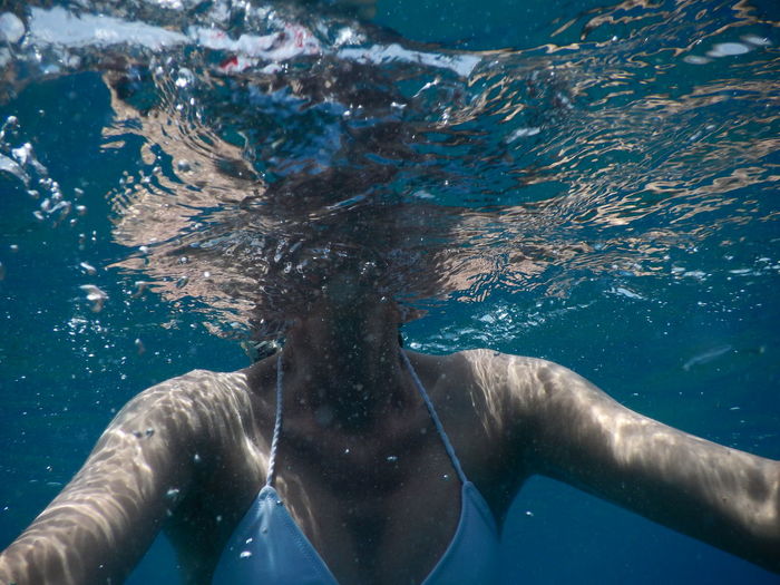 Midsection of woman swimming in sea