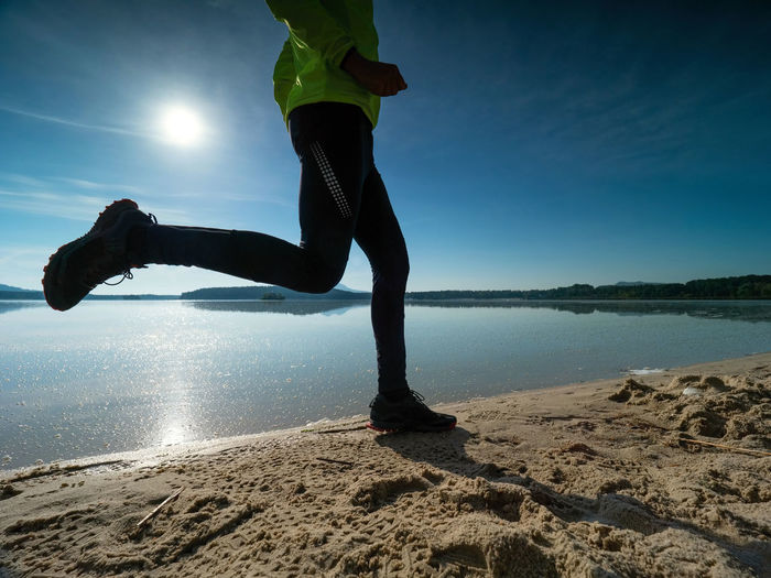 Dynamic silhouette of athlete in compression running tights jogging. man doing intervals workout
