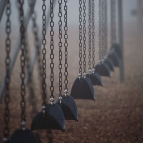 Close-up of empty swings at playground