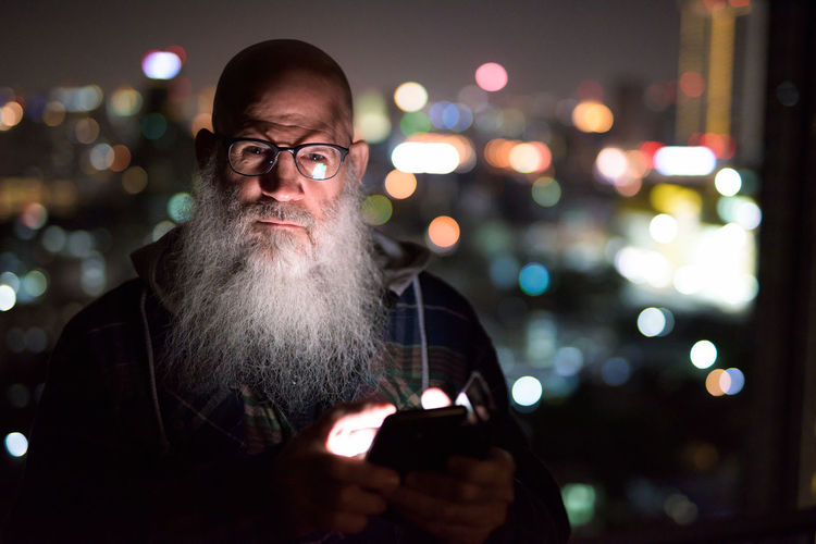 Portrait of man using mobile phone at night