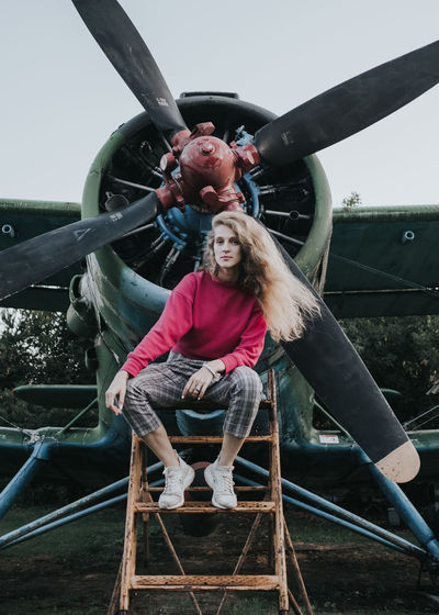 Woman sitting on slide in front of a plane