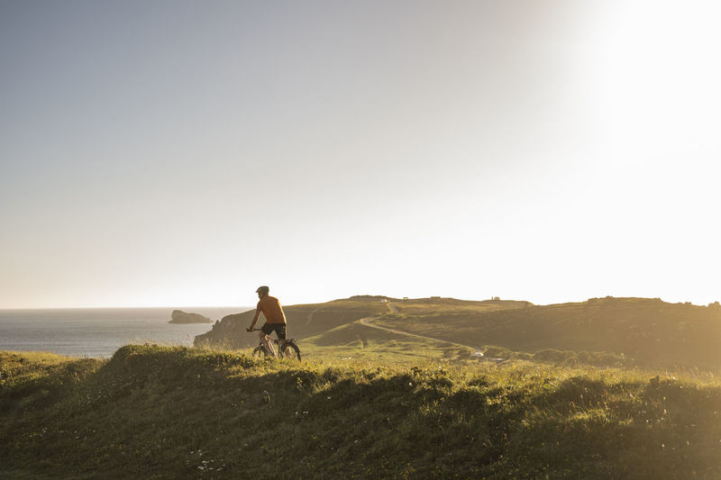 Mature male sportsperson riding mountain bike on green grass
