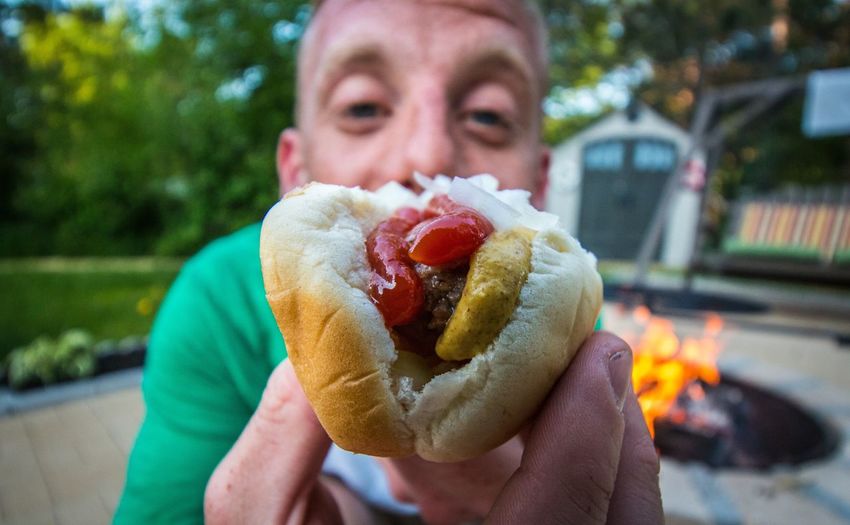 Portrait of man showing hot dog
