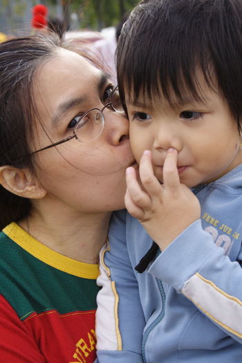 Portrait of mother kissing cute son