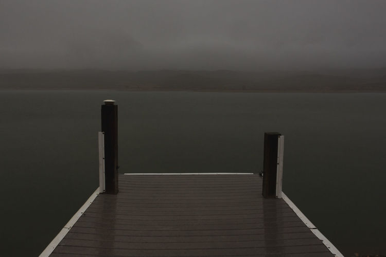 Pier over lake against sky