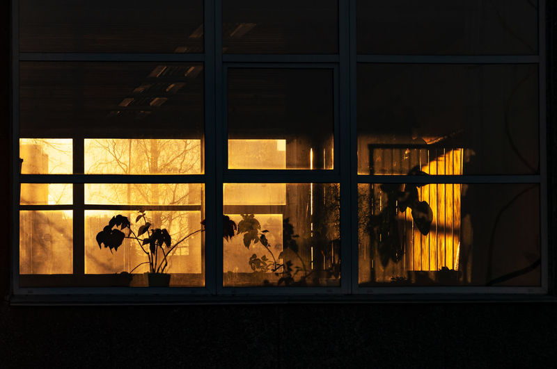 Silhouette people seen through glass window