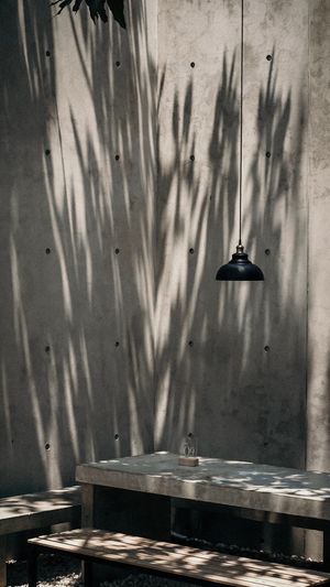 Pendant light hanging over table against wall