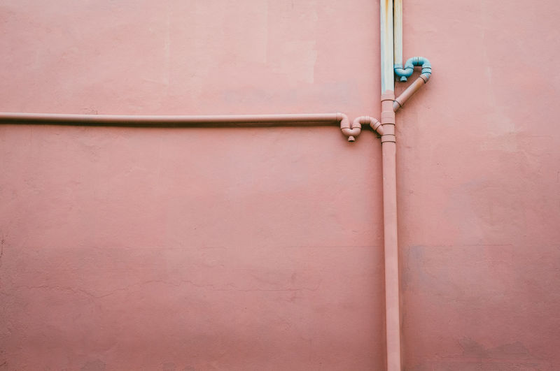 Water pipes on pink wall