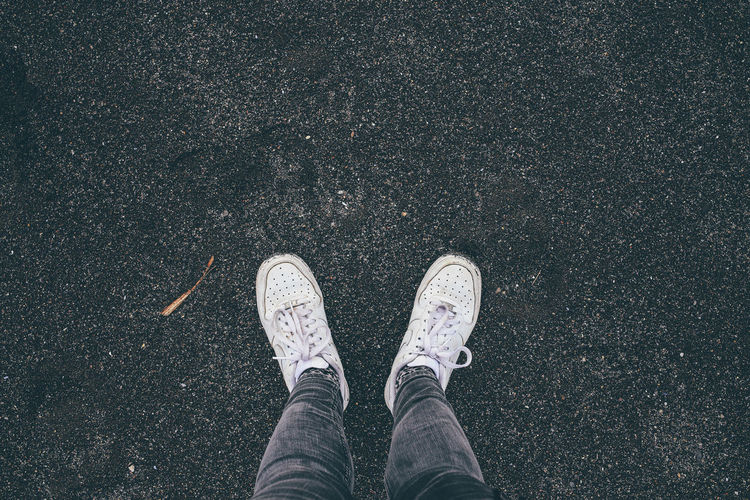 Low section of man standing on road