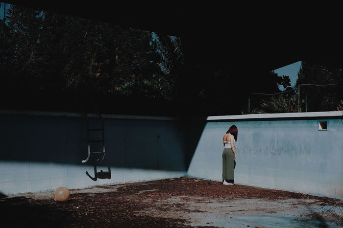 Full length of woman standing in abandoned swimming pool