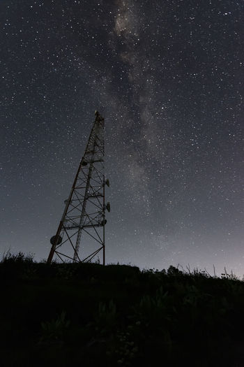 Low angle view of tower on field against sky at night