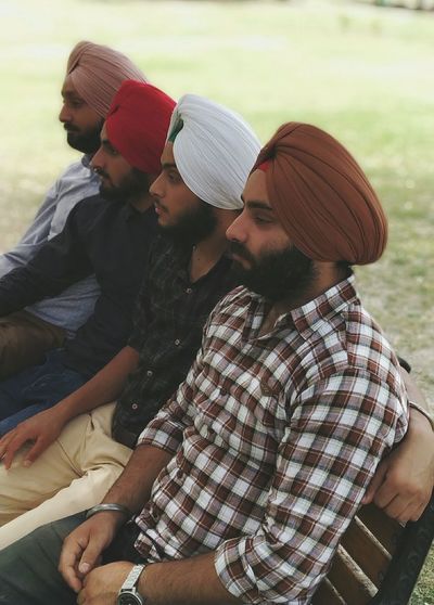 Friends wearing turbans sitting on bench