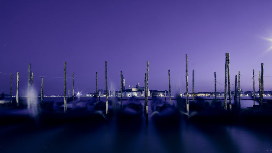 Panoramic view of illuminated harbor against sky at dusk