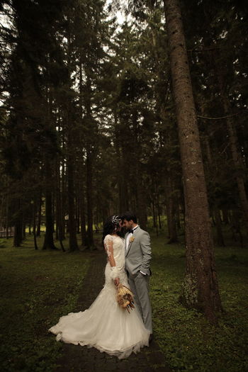 Newlywed couple standing in forest