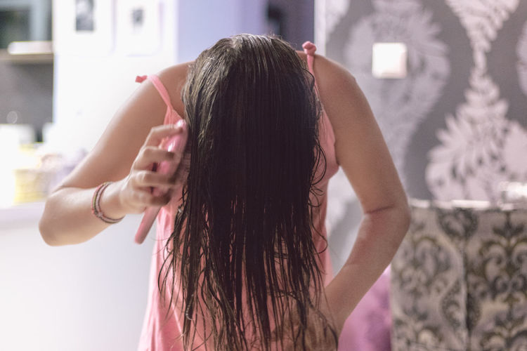 Woman brushing hair at home