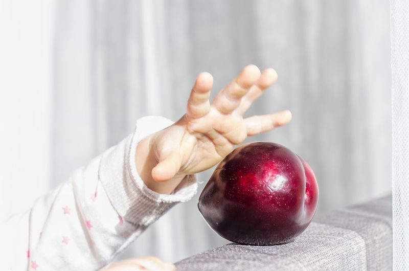 Catch your plum with your child's hand.