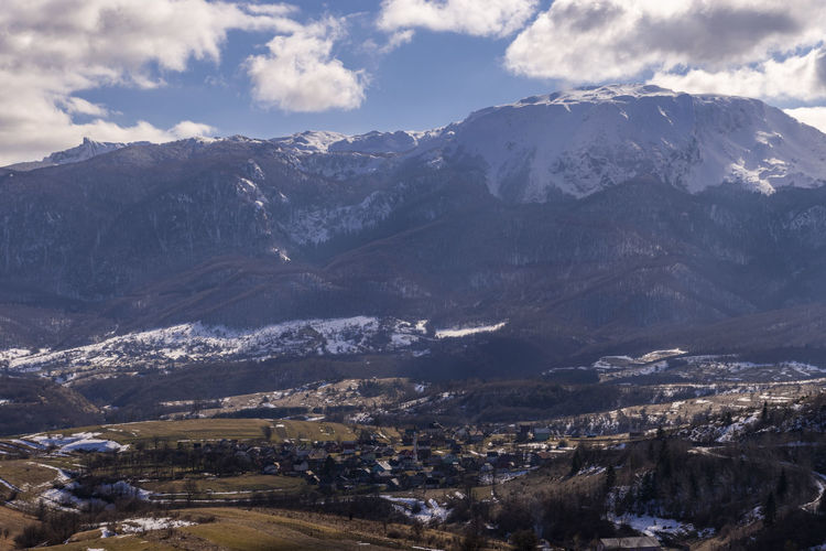 Aerial view of townscape and mountains against sky