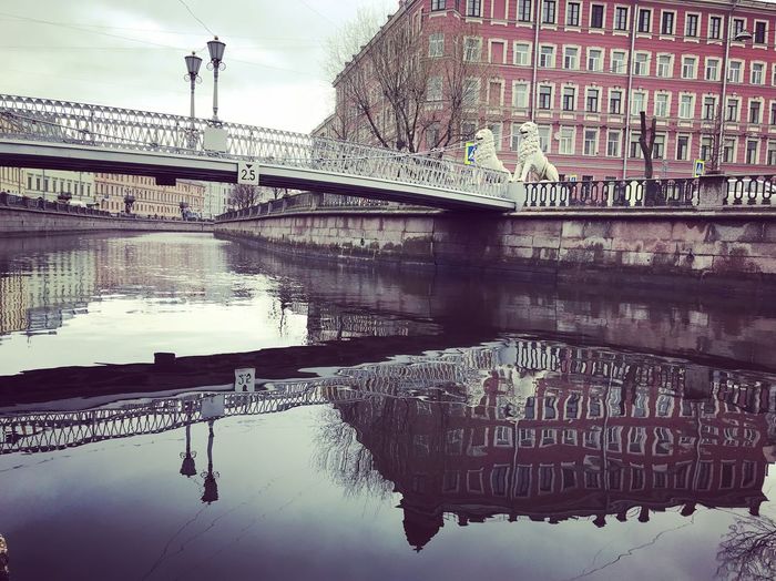 Bridge over river against buildings in city