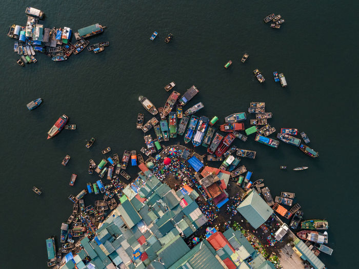 Aerial view of boats moored at harbor in sea