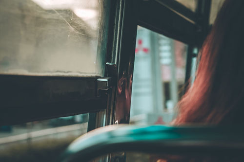 Rear view of woman by window in bus