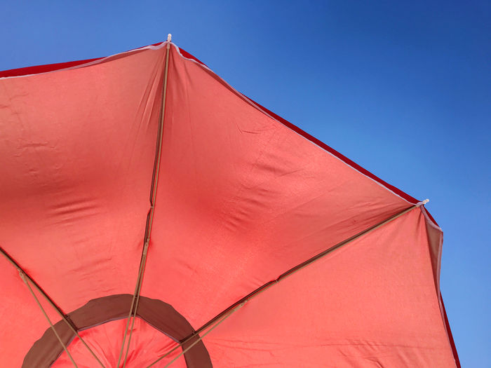 Low angle view of parasol against clear sky