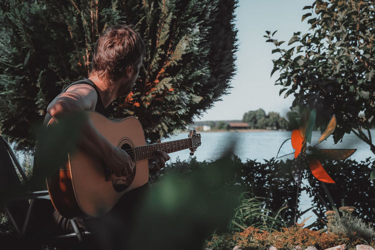 Man playing guitar in lake