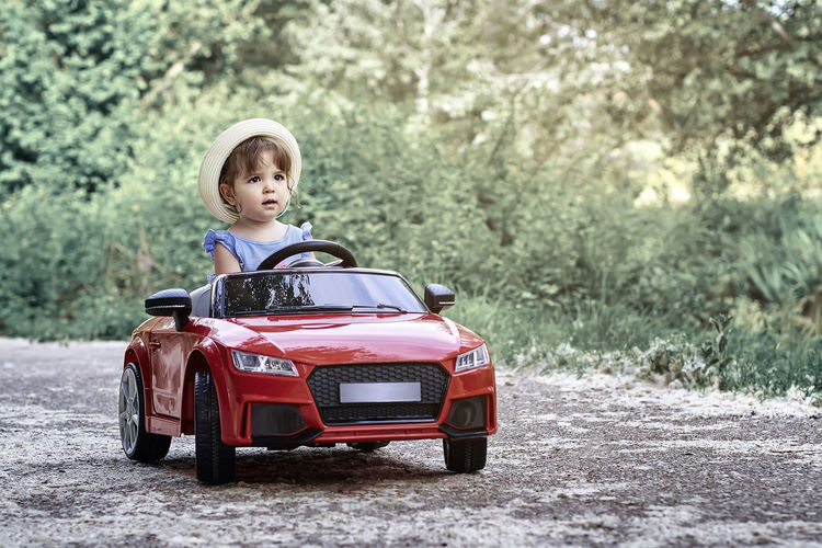 Boy sitting on toy car