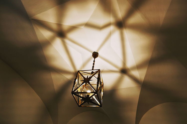 Low angle view of illuminated lamp hanging on ceiling