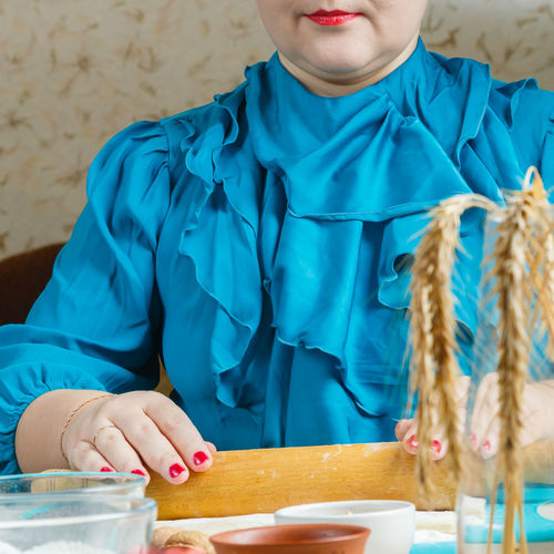 Midsection of young woman with hands on table