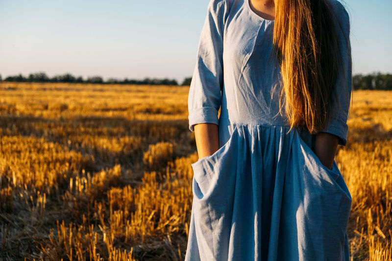 Physical and mental well-being. faceless portrait of woman in linen dress enjoys nature on sunset