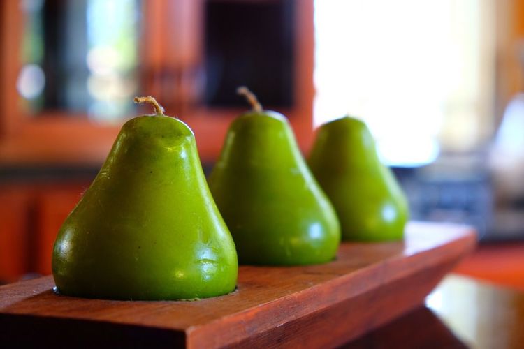 Close-up of pear shaped candles in wooden holder