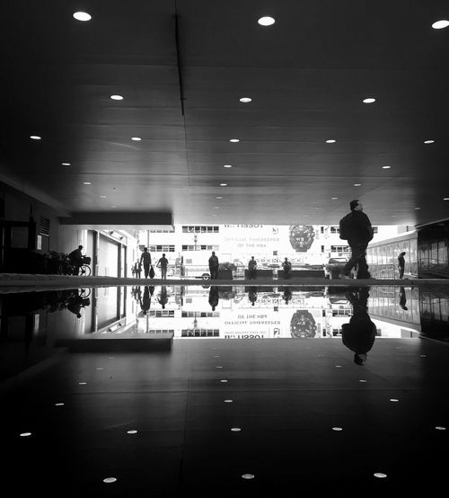 People on illuminated walkway in city