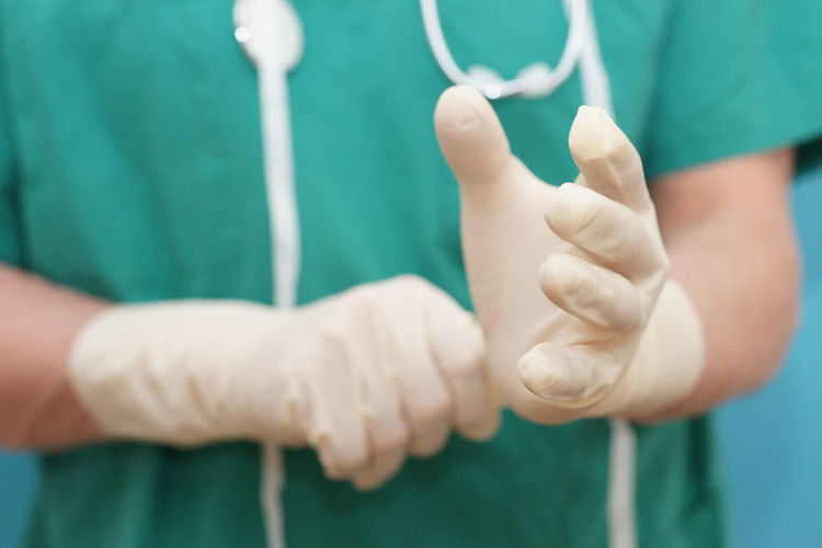 Close-up of surgeon with gum gloves preparing for surgery