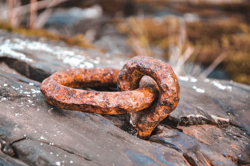 Close-up of rusty metal chain on rock