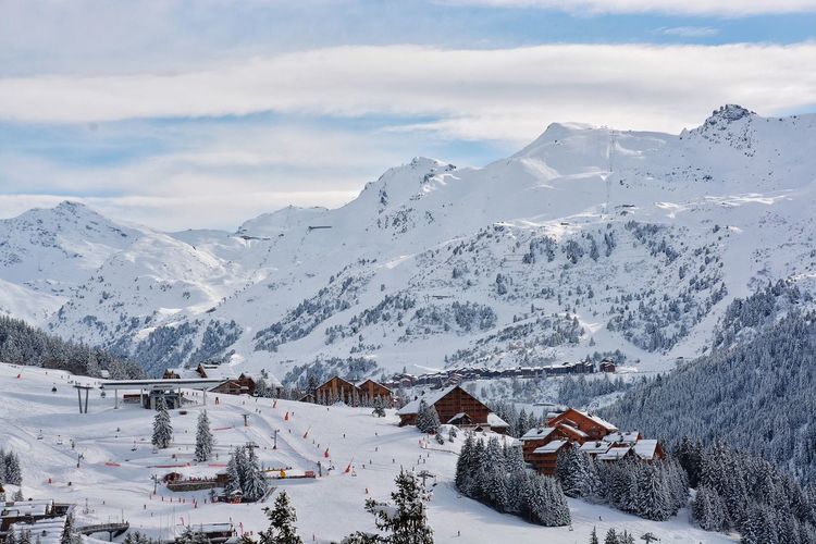 Scenic view of snow covered mountains against cloudy sky