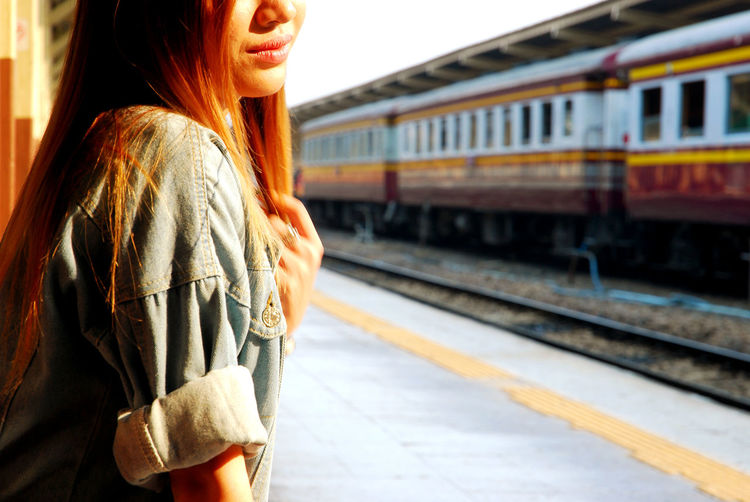 Side view of young woman on railroad platform
