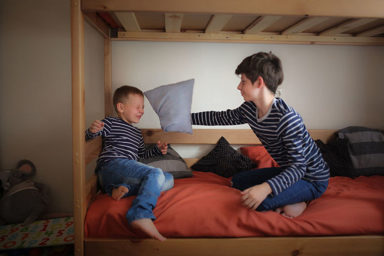 Brothers play on two bunk beds in the nursery, concept relationships and childhood