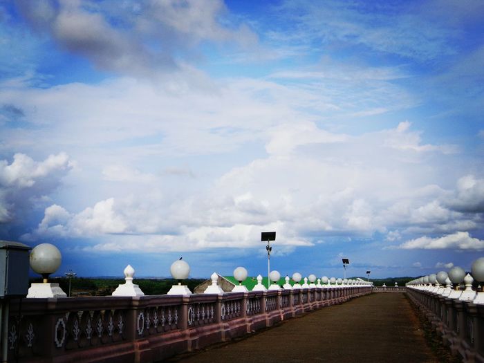 Street by bridge against sky