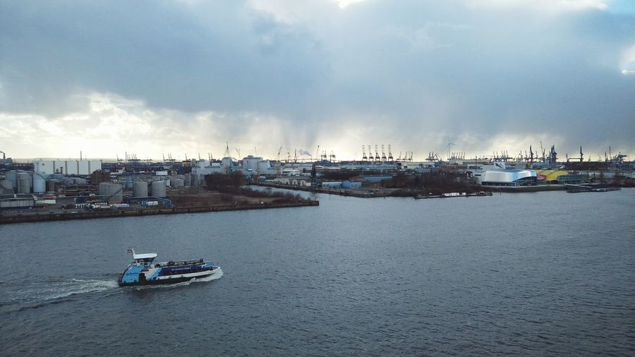Boats moored at harbor against sky