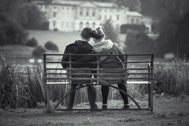 Rear view of couple sitting on bench
