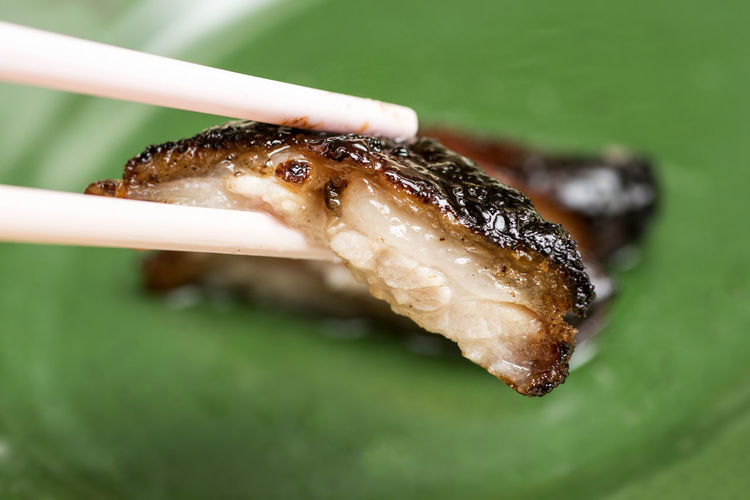 Close-up of grilled fish on chopsticks