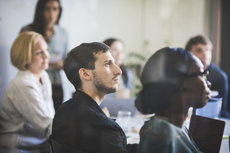Creative business professionals listening during meeting in board room