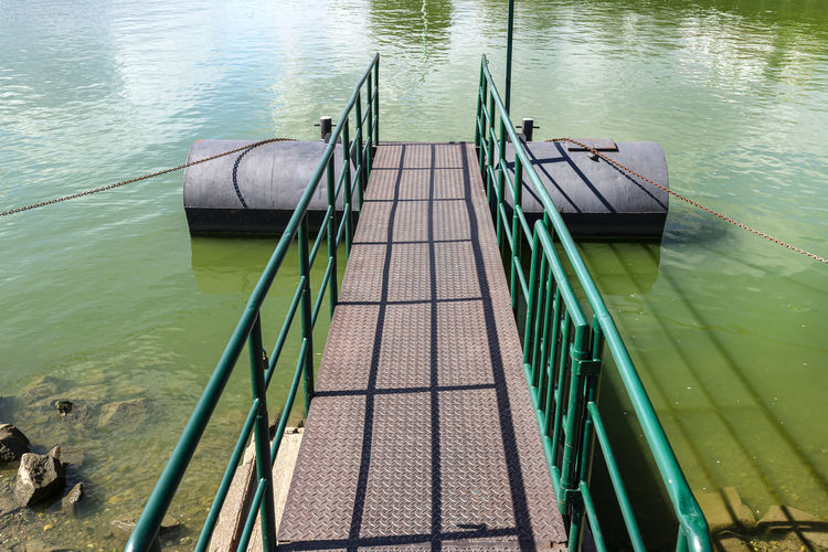 A metal platform protruding from the river bank on air tanks, a pier to the entrance to the ship.