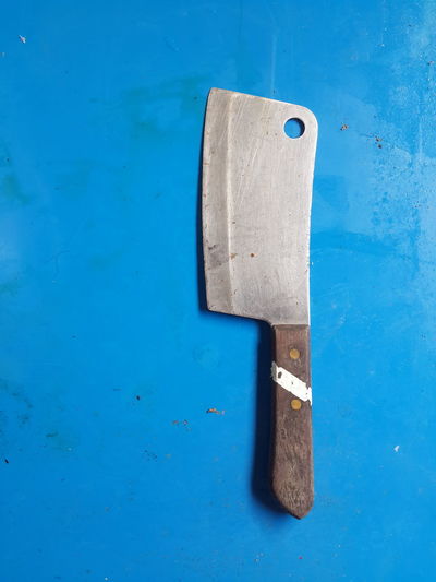 Close-up of meat cleaver on blue background