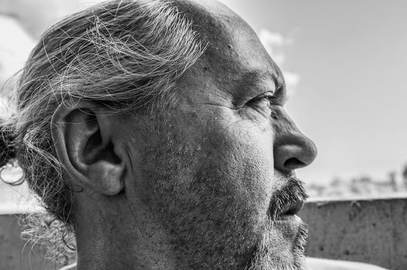Black and white profile portrait of serious man with beard and graying hair collected