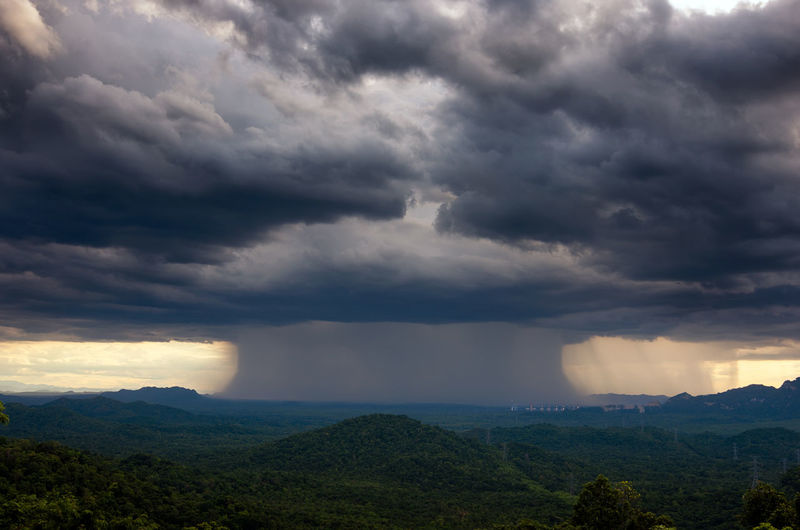 Beautiful rainstorm in the forest over a coal-fired power plant, mae moh, lampang, thailand.