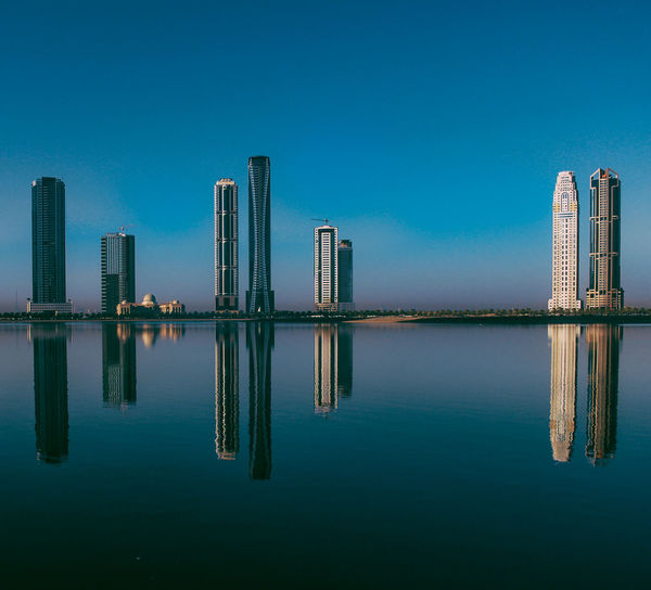 Skyscraper in city against clear blue sky