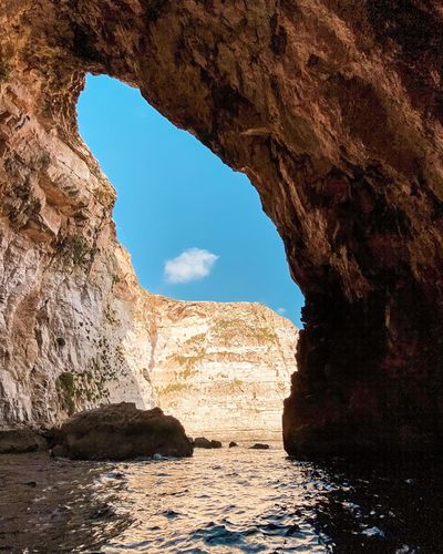 Rock formations by sea against sky