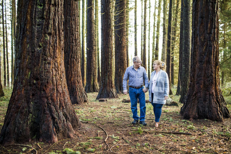 Romantic retired couple walking through the forest.