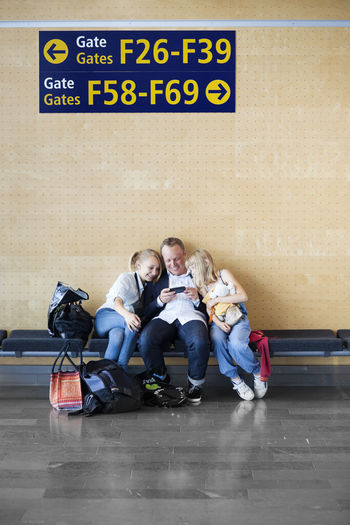 Father with two daughters sitting at airport